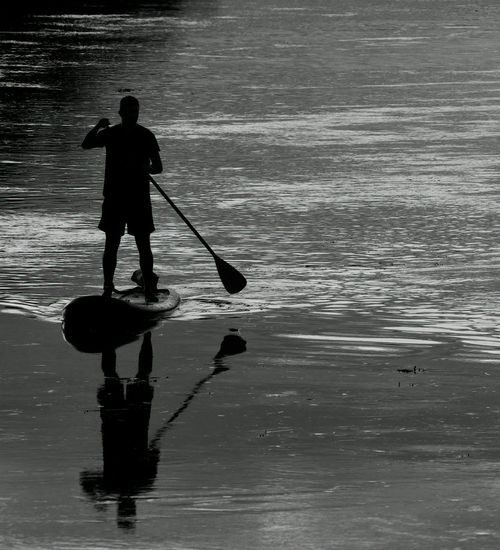 A silhouette of a person stretching during sunrise.